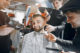 Barbeiros cortando cabelo do cliente